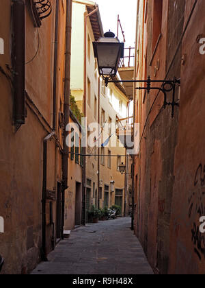 Typischen schmalen Fußgängerzone im Schatten mit Straßenlaternen auf reich verzierte Halterungen in Pisa, Italien Stockfoto