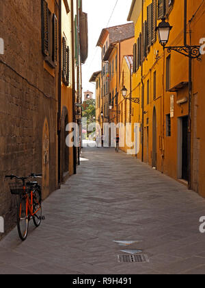 Ferner zahlen in typischen schmalen Fußgängerzone im Schatten mit abgestellten Fahrrad & Straßenlaternen auf reich verzierte Halterungen in Pisa, Italien Stockfoto