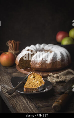 Landhausstil Apple Bundt Cake bestreut mit Puderzucker auf alten Holztisch Stockfoto