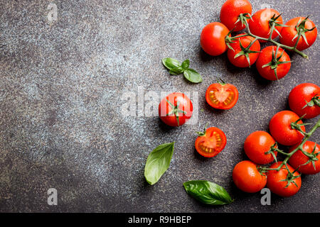 Frische Trauben Tomaten mit Basilikum und grobem Salz, Ansicht von oben mit der Kopie Raum Stockfoto