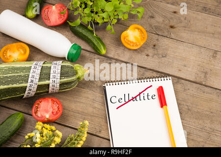 Diätplan - Mark Squash, Notizblock mit Text "Keine Cellulite", Gemüse und Maßband auf braune Holztisch Stockfoto