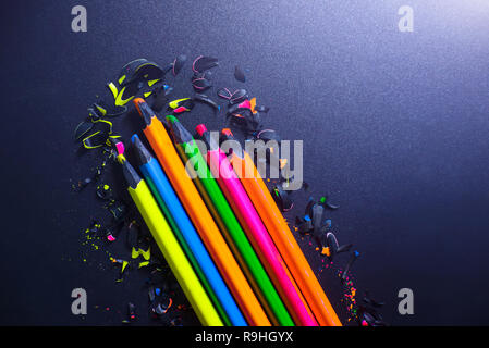 Helle farbige Abstraktion auf einem dunklen Hintergrund. Chips von buntstiften. Stockfoto