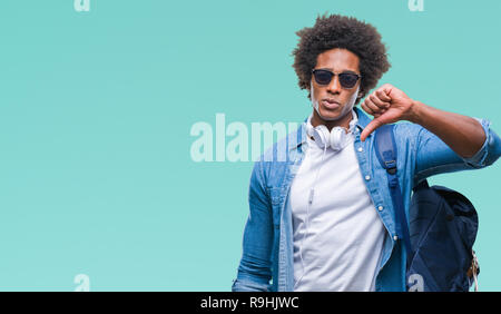 Afro-amerikanischer Mann mit Kopfhörern und Rucksack über isolierte Hintergrund mit Verärgerten Gesicht, negatives Vorzeichen zeigen Abneigung mit Daumen nach unten, Ablehnung Stockfoto