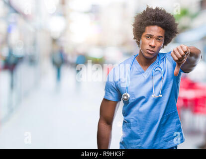 Afro-amerikanische Chirurg Arzt Mann über isolierte Hintergrund unzufrieden und wütend, Ablehnung und negativ mit Daumen nach unten Geste. Schlechte expre Stockfoto