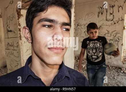 Teenager Jungs Fußball spielen innerhalb des zerstörten Haus Stockfoto