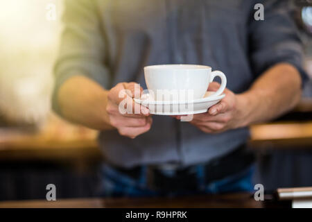 Nahaufnahme der männlichen Barista, Tasse frischen Kaffee. Stockfoto
