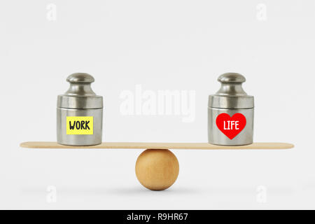Gewichte mit den Worten die Arbeit und das Leben auf dem Papier Hinweis auf Balance Scale geschrieben - Konzept der Balance zwischen Arbeit und Leben Stockfoto