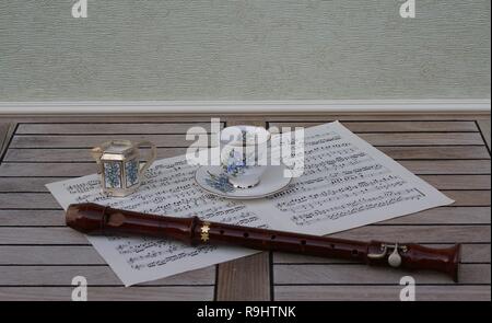 Englisch Teetasse mit Untertasse, creme Kanne, mit floralem Dekor, und ein Block Flöte auf einem Blatt von Musik Stockfoto