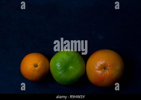 Schöne saftige appetitlich Obst Zitrusfrüchte Grapefruit Orange sweetie Leuchten im dunklen schwarzen Hintergrund der unteren Foto mit Copyspace closeup Makro Stockfoto