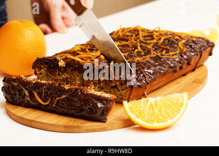 Hausfrau abgeschnittene Stück Schokolade und Orange Kuchen Stockfoto