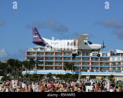 Aktion im Princess Juliana Airport (SXM) auf der karibischen Insel Sint Maarten als FedEx Cessna kommt in über Maho Beach zu landen. Stockfoto