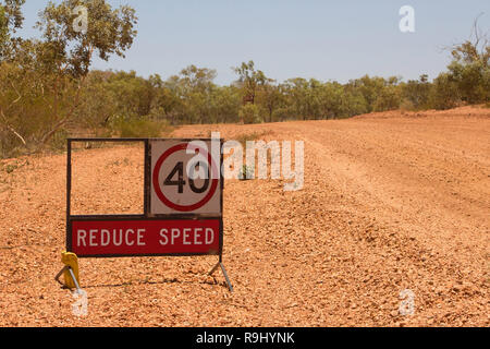 Geschwindigkeit Warnschild auf einer verlassenen Straße arbeitet im Outback von Queensland, Australien reduzieren Stockfoto