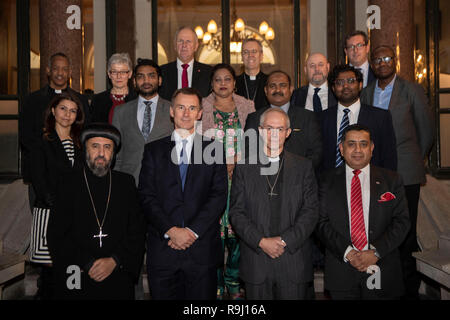 Außenminister Jeremy Hunt (vordere Reihe 2. links), der Erzbischof von Canterbury Justin Welby (vordere Reihe zweiter von rechts) und Herr Ahmad (rechts) beigetreten sind, werden durch andere christliche Führer, darunter Erzbischof Angaelos der koptisch-orthodoxen Kirche in Großbritannien (links), und Würdenträgern und Politikern mit Überlebenden der Verfolgung der Christen bei einem Treffen im Auswärtigen Amt in Central London. Stockfoto