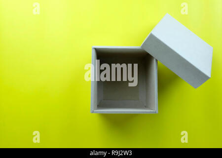 Leeren braunen Karton ruht auf gelbem Papier, und haben Sie Raum für Design in Ihrem Weihnachten arbeiten Konzept. Stockfoto