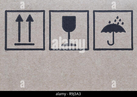 Symbol logo neben einem braunen Karton in sorgfältiger Transport. Stockfoto