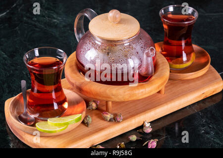 Traditionelle türkische Tasse Tee, Teezeremonie, Tasse frisch gebrühter schwarzer Tee, warmes, weiches Licht, dunkler Marmor Hintergrund Stockfoto