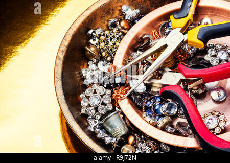 Schmuck und Edelsteine auf Gold Hintergrund. Tools für die Schmuckherstellung. Stockfoto