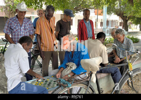 Trinidad, Cuba-April 04,2016: Männer Domino spielen auf der Straße, während andere Männer sehen Sie Stockfoto