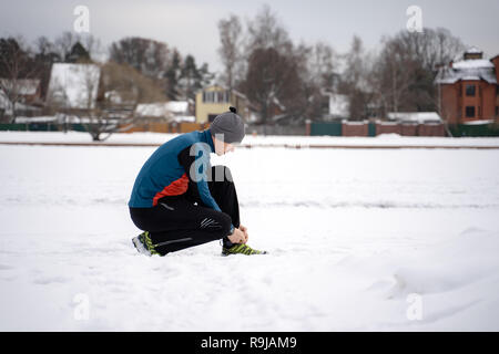 Runner Männer, die versuchen, Laufschuhe, die Vorbereitungen für den Winter laufen. Stockfoto