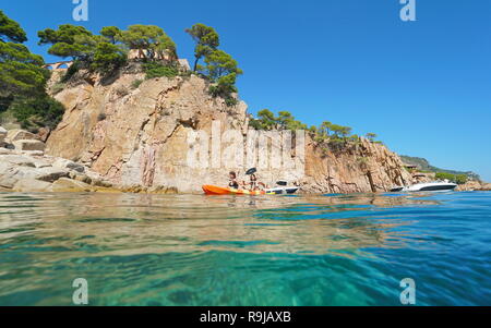 Junge Frauen Paddel Kayak auf dem Mittelmeer vor einer felsigen Küste, Aiguablava, Begur, Katalonien, Costa Brava, Spanien Stockfoto