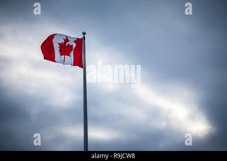Kanadische Flagge, mit seinem Wahrzeichen Red Maple Leaf, den Verzicht auf die in der Luft auf einer Stange, outoors, während einem trüben regnerischen Nachmittag in Ottawa, Kanada Bild von Th Stockfoto