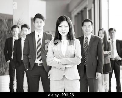 Porträt einer Mannschaft der Erfolgreichen asiatischen Unternehmer und Unternehmerinnen, in die Kamera lächeln suchen, Schwarz und Weiß. Stockfoto