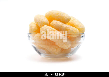 Gelber Mais Puffs in eine Glasschüssel isoliert auf weißem Hintergrund. Crunchy aromatisiert aufgeblasen Snacks. Party, Film, TV, Game Snacks. Stockfoto