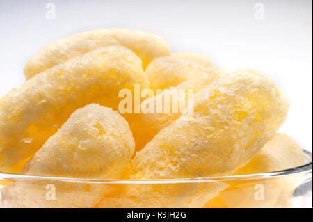 Gelber Mais Puffs in einer Glasschale. Crunchy aromatisiert aufgeblasen Snacks. Party, Film, TV, Game Snacks. Stockfoto