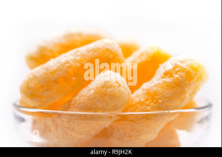 Gelber Mais Puffs in einer Glasschale. Crunchy aromatisiert aufgeblasen Snacks. Party, Film, TV, Game Snacks. Stockfoto