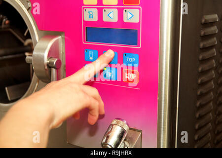 Weibliche Konditor in Chef einheitliche Herstellung von Eis mit Eis Maschine an Ice Cream Factory. Frau ist drücken Sie auf Start und Programmierung. Stockfoto