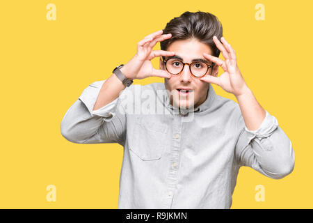 Jungen gutaussehenden Mann Brille über isolierte Hintergrund versuchen, Augen mit den Fingern, schläfrig und müde für morgendliche Müdigkeit zu öffnen. Stockfoto