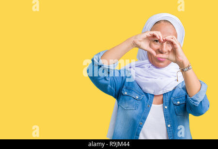 Mittleres Alter östlichen arabischen Frau mit arabischen Hijab über isolierte Hintergrund tun Herzform mit Hand und Finger lächelnd durch Zeichen Stockfoto