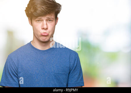 Jungen gutaussehenden Mann trägt blaue T-Shirt über isolierte Hintergrund gedrückt und für Not, Sorge und schrie wütend und ängstlich. Traurigen Gesichtsausdruck. Stockfoto