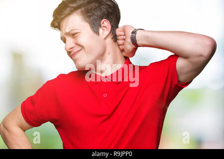 Jungen gutaussehenden Mann tragen rote T-Shirt über isolierte Hintergrund Leiden der Nacken Schmerzen Verletzungen, Hals mit der Hand berühren, Muskelschmerzen Stockfoto