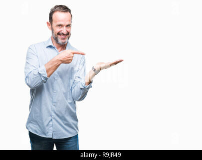 Mittleres Alter hoary Senior Business Mann über isolierte Hintergrund erstaunt und lächelt in die Kamera während der Präsentation mit Hand und zeigte mit dem Finger. Stockfoto