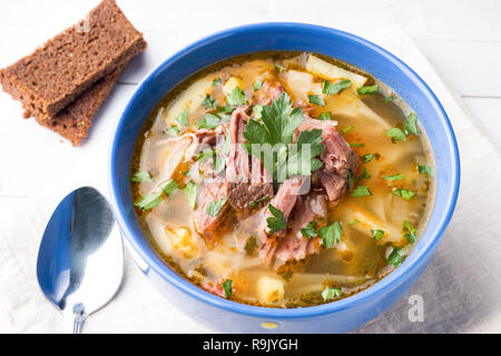 Russische traditionelle Kohlsuppe mit Fleisch und frischen Kräutern auf einem Leuchttisch Stockfoto
