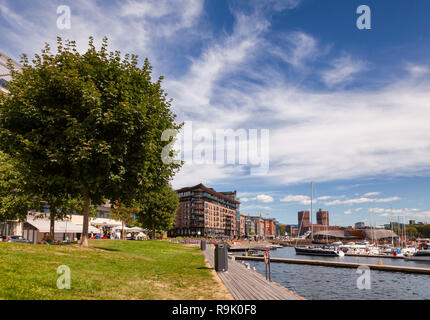 OSLO, Norwegen - 23. JULI 2018: City Park und am Pier renoviert Tjuvholmen Hafenviertel Aker Brygge Nachbarschaft und Marina ist in backgrou gesehen Stockfoto