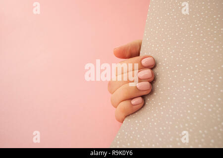 Die junge Frau mit schönen Maniküre auf Rosa und Beige Hintergrund mit Copyspace. Stockfoto