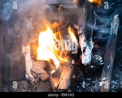 Brennendes Feuerholz und Holzkohle Grill in der Nähe Stockfoto
