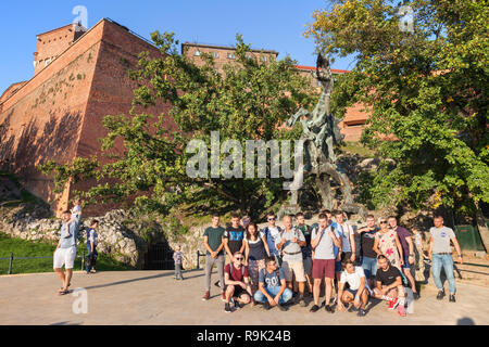 Polen, Krakau, Gruppe von Menschen im Wawel Dragon (Polnisch: Smok Wawelski) Metall Skulptur im Jahre 1969 entworfen von Bronisław Chromy, Wahrzeichen der Stadt in her Stockfoto