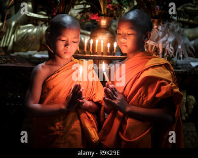 KYAING TONG, MYANMAR - ca. Dezember 2017: Mönche im Wat Jong Kham Kloster mit Kerzen in die Kamera schauen. Stockfoto