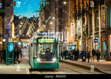 Helsinki, Finnland - 6. Dezember 2016: Straßenbahn fährt von der Haltestelle Aleksanterinkatu Straße. Nacht Abend Weihnachten neues Jahr festliche Straße Illumina Stockfoto