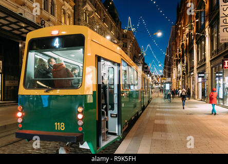 Helsinki, Finnland - 6. Dezember 2016: Straßenbahn fährt von der Haltestelle Aleksanterinkatu Straße. Nacht Abend Weihnachten neues Jahr festliche Straße Illumina Stockfoto