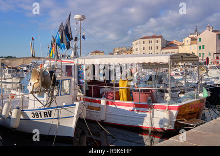 Blick auf die Stadt Rovinj in Kroatien. Fischer im Hafen, sein Netz anordnen auf seinem Schiff. Stockfoto