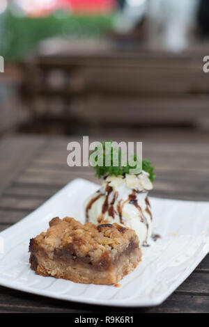 Granny Smith Äpfel mit Zimt und Gewürze bröckeln, und eine Kugel Vanilleeis. Stockfoto