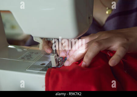 Frau Näherin arbeiten, die Kleidung auf einer Nähmaschine. Stockfoto