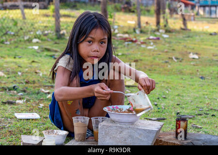 Thakhek, Laos - 19. April 2018: Lokale chil spielen eine Mahlzeit mit Schlamm aus einem Fluss in einer abgelegenen ländlichen Gegend von Laos zu machen Stockfoto