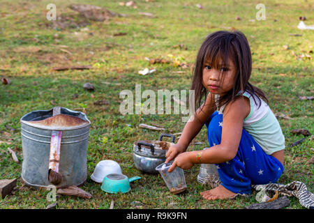 Thakhek, Laos - 19. April 2018: Lokale chil spielen eine Mahlzeit mit Schlamm aus einem Fluss in einer abgelegenen ländlichen Gegend von Laos zu machen Stockfoto