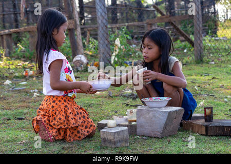 Thakhek, Laos - 19. April 2018: Lokale spielen Kinder eine Mahlzeit mit Schlamm aus einem Fluss in einer abgelegenen ländlichen Gegend von Laos zu kochen Stockfoto