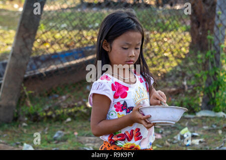 Thakhek, Laos - 19. April 2018: Lokale chil spielen eine Mahlzeit mit Schlamm aus einem Fluss in einer abgelegenen ländlichen Gegend von Laos zu machen Stockfoto